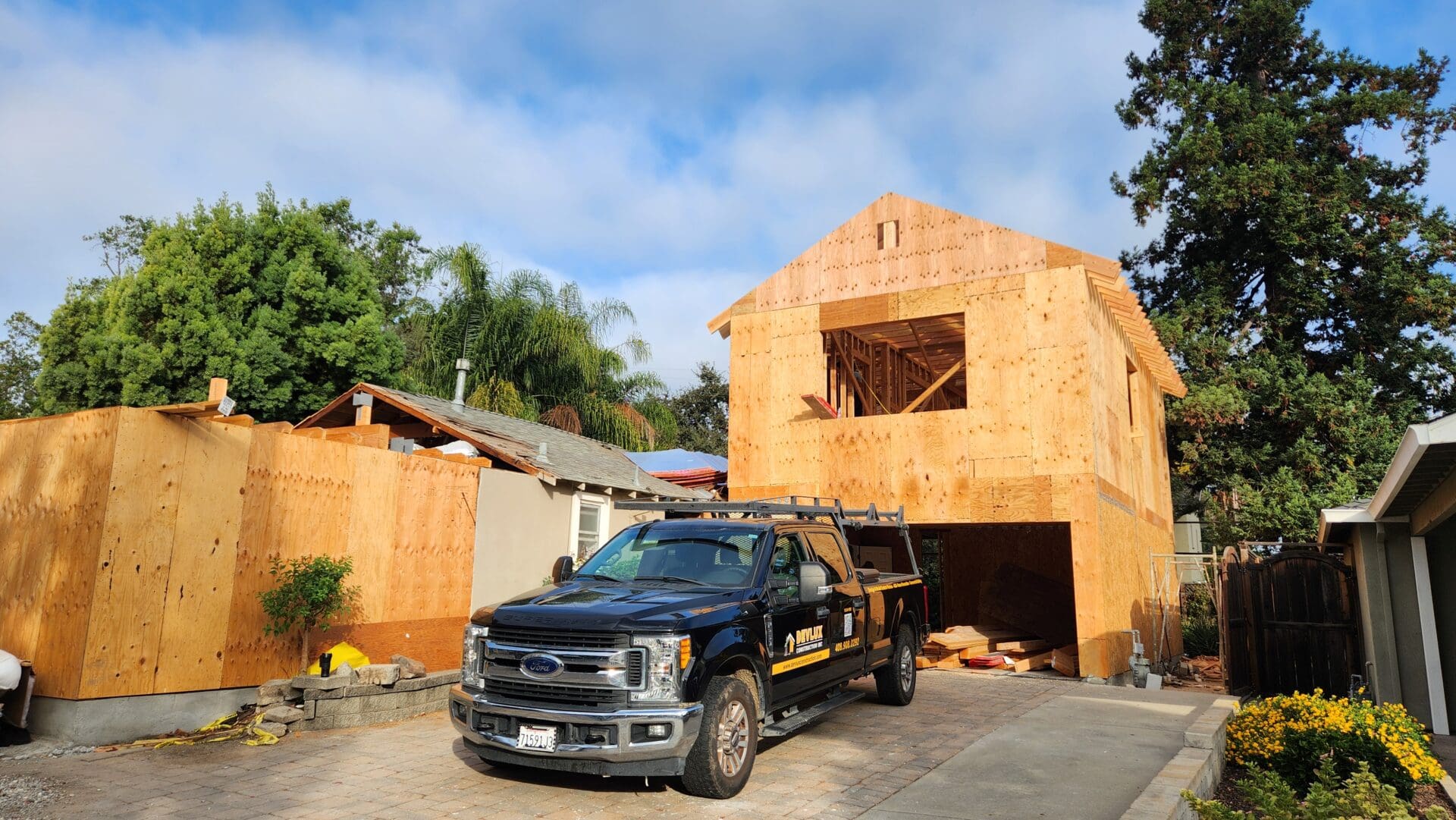 A truck parked in front of a house under construction.