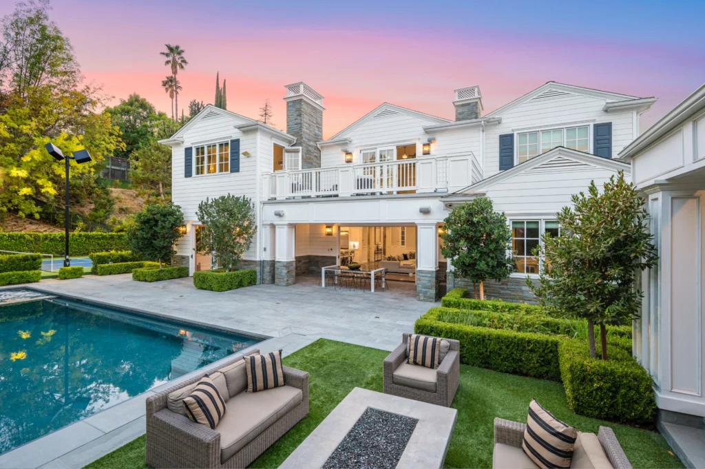 A large white house with a pool in the back yard.