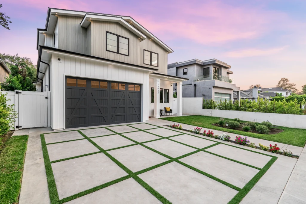 A large driveway with grass in front of it.