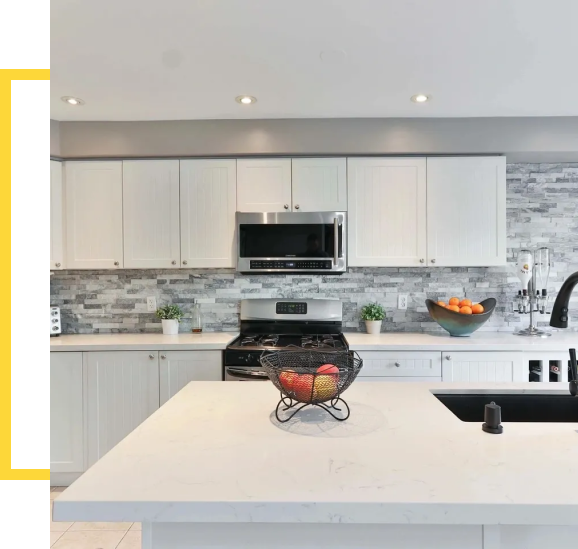 A kitchen with white cabinets and black appliances.