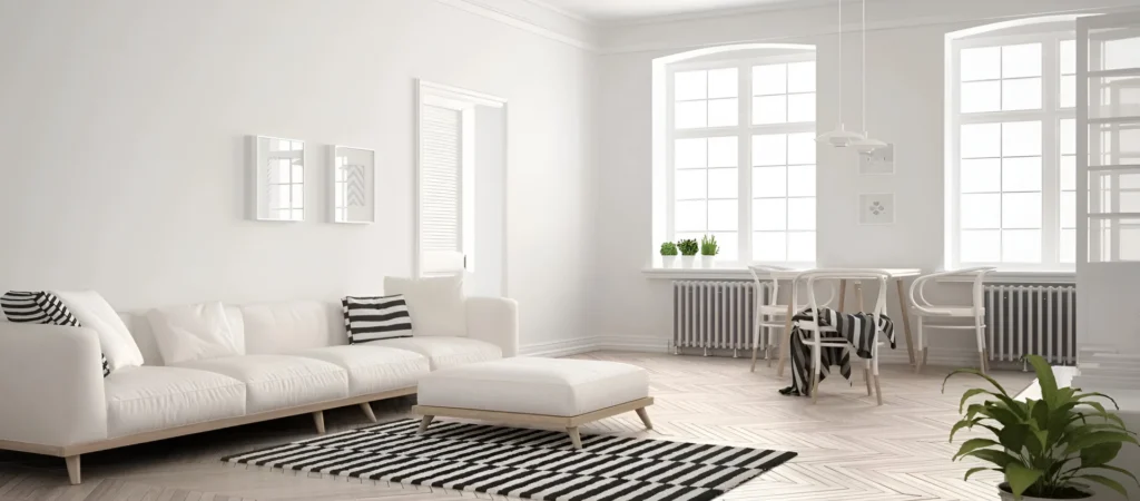 A living room with white furniture and black and white striped rug.